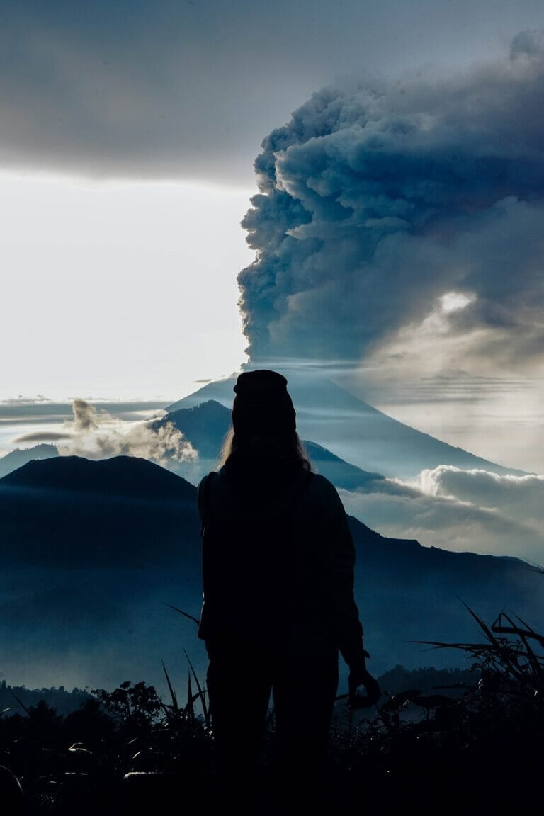 woman looking at a smoking volcano - Embracing a Growth Mindset